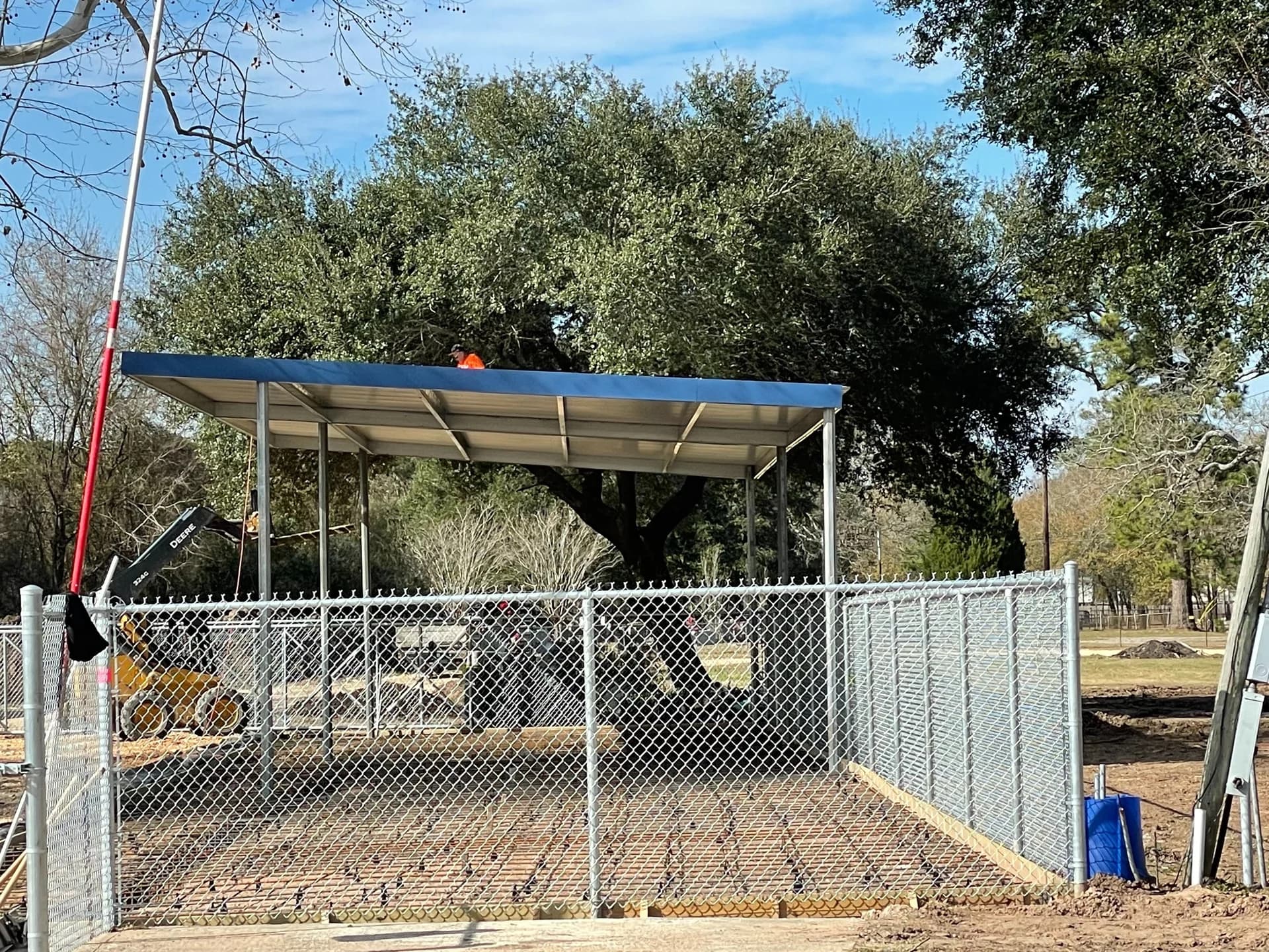 Metal pavilion being installed beside a mature oak tree