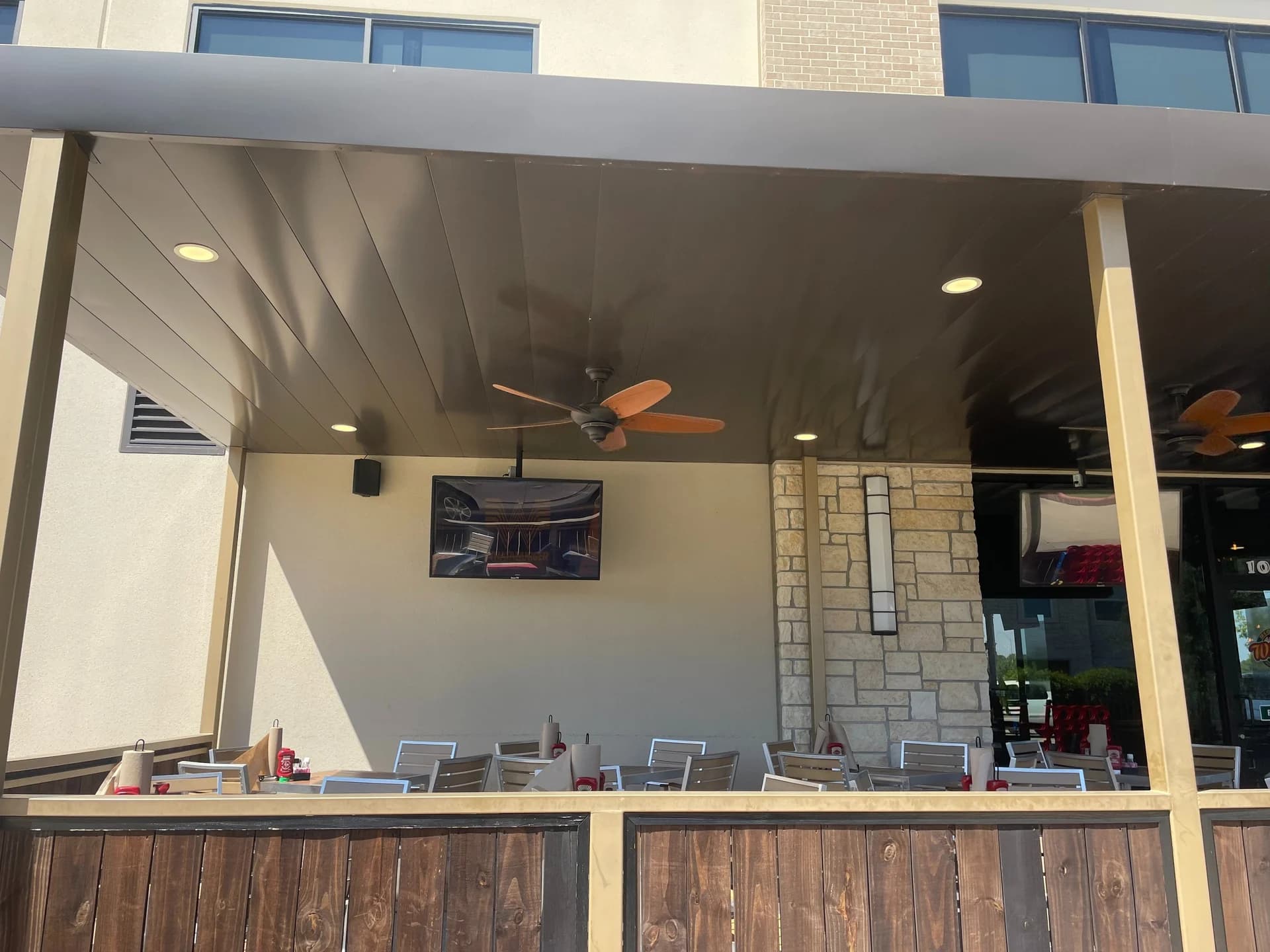 Finished restaurant patio cover with ceiling fans and dining tables
