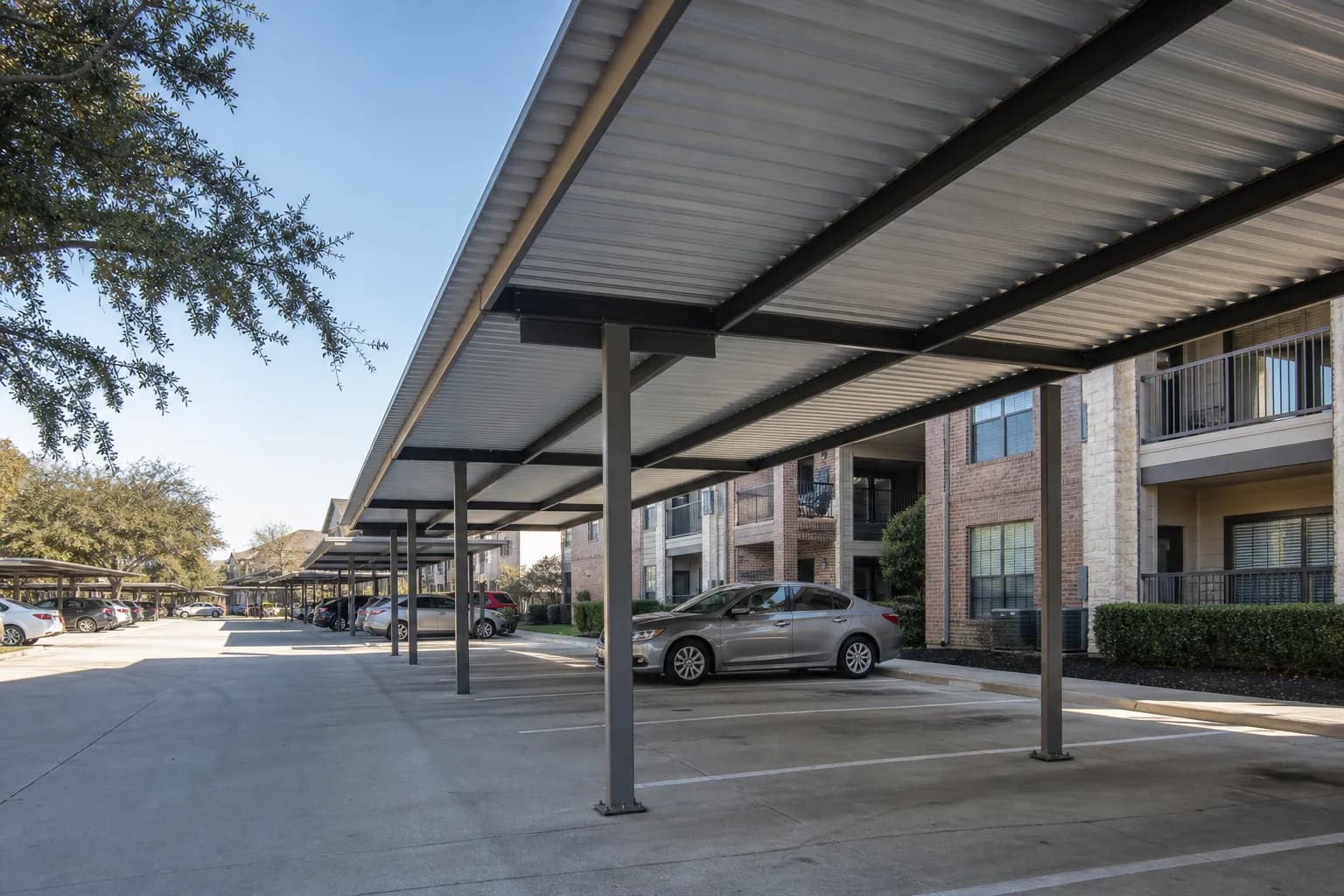 Rows of metal apartment covers beside a Houston multifamily building