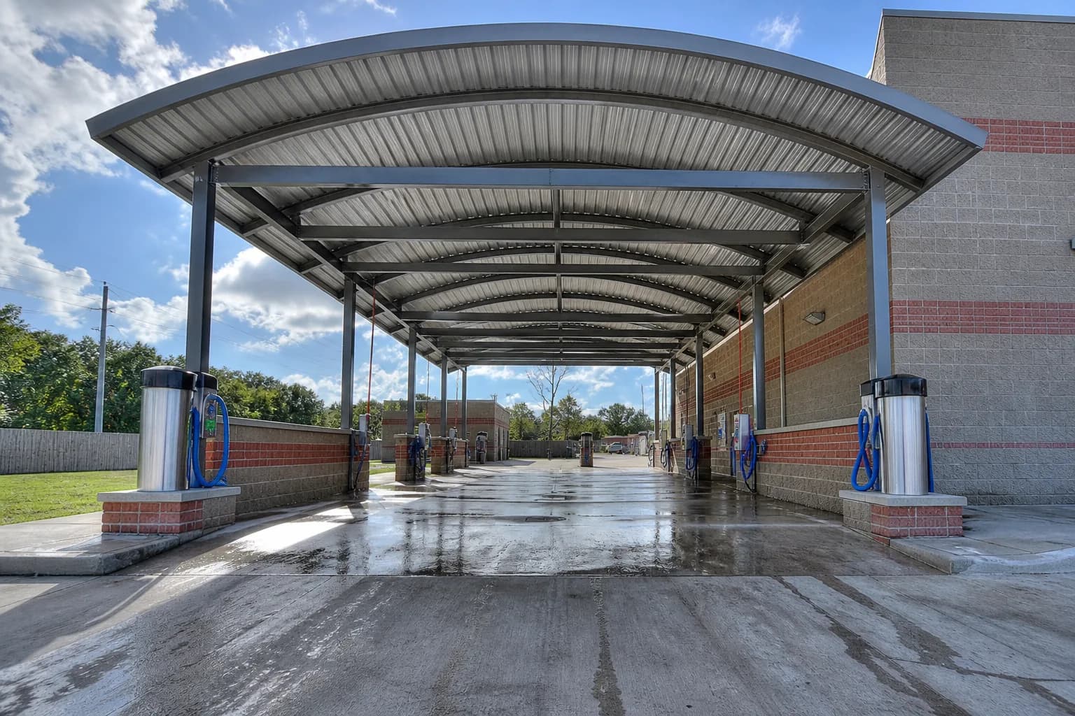 Open metal car wash shelter canopy over a wash bay
